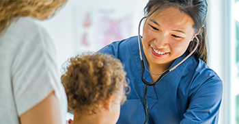 A pediatrician examining a baby while the mother holds her