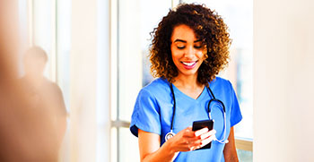 A doctor dictating a patient visit to a transcription specialist on her mobile phone