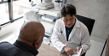 A doctor showing a paper document to a patient