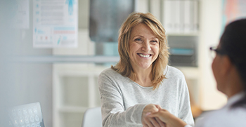 A patient and a doctor shaking hands