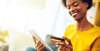 A woman paying a medical bill using her tablet and credit card