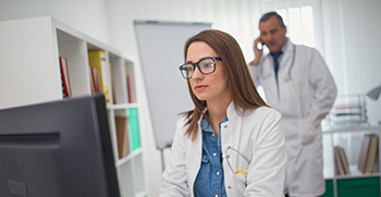 Two doctors discussing care insights at a computer